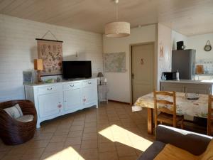 ein Wohnzimmer mit einem TV und einem Esszimmer in der Unterkunft le lansquenet in Rorbach-lès-Dieuze