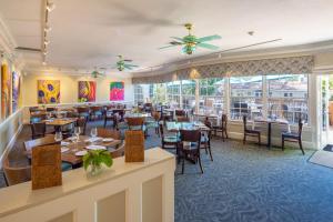 um restaurante com mesas, cadeiras e janelas em Shangri-La Springs em Bonita Springs