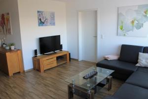 a living room with a couch and a tv at Moderne 3-Zimmerwohnung, an Skipiste, mit Aussicht in Flumserberg