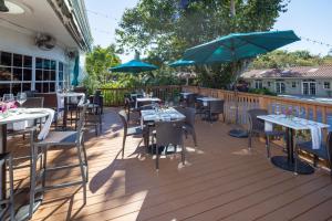 a deck with tables and chairs and umbrellas at Shangri-La Springs in Bonita Springs
