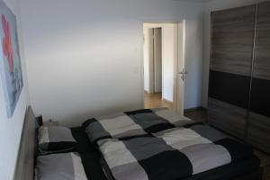 a bedroom with a black and white bed in a room at Moderne 3-Zimmerwohnung, an Skipiste, mit Aussicht in Flumserberg