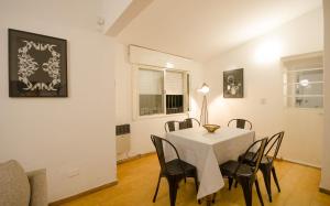 a dining room with a white table and chairs at Casa en Villa Carlos Paz con Pileta , Quincho y Jardín a Pasos del Centro in Villa Carlos Paz