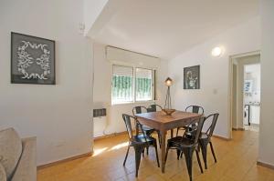 a dining room with a table and chairs at Casa en Villa Carlos Paz con Pileta , Quincho y Jardín a Pasos del Centro in Villa Carlos Paz +21 photos