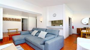 ヴィラモウラにあるPalmeiras do Golfe 160 - Clever Detailsのリビングルーム(青いソファ付)、キッチン