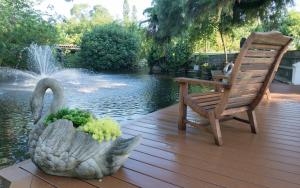 a statue of a swan and a chair on a wooden deck at Shangri-La Springs in Bonita Springs