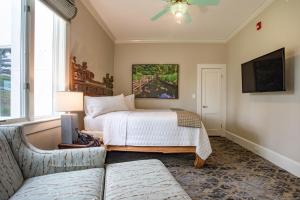 a bedroom with a bed and a couch and a tv at Shangri-La Springs in Bonita Springs