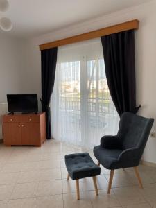 a living room with a chair and a tv at The Gemini Suites in Kos Town
