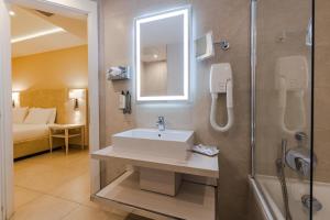 a bathroom with a sink and a shower at Maritim Antonine Hotel & Spa in Mellieħa