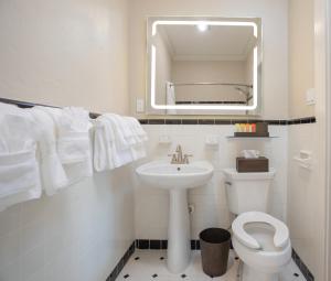 a white bathroom with a sink and a toilet at Shangri-La Springs in Bonita Springs