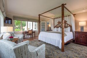 a bedroom with a canopy bed and a living room at Shangri-La Springs in Bonita Springs