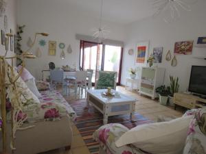 a living room with couches and a tv and a table at Casa Burgos in Corralejo