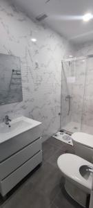 een witte badkamer met een toilet en een wastafel bij APARTAMENTO HUERTA NUEVA in Málaga