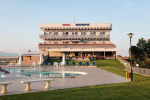 a large building with a swimming pool in front of a building at Vosporos Hotel in Komotini