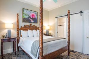 a bedroom with a four poster bed and a table at Shangri-La Springs in Bonita Springs