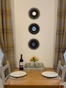 奧本的住宿－Newly refurbished town centre apartment，一张桌子,上面放着一瓶葡萄酒和两面镜子