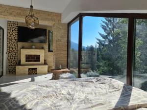 a bedroom with a fireplace and a large window at Penthouse luxury Predeal View in Predeal