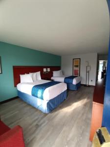 2 Betten in einem Hotelzimmer mit grünen Wänden in der Unterkunft Travelodge by Wyndham Petersburg in Petersburg