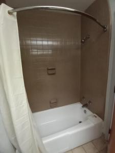 a white bath tub in a bathroom with a shower at Travelodge by Wyndham Petersburg in Petersburg