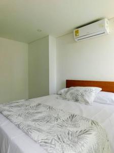 a white bed in a white room with at Apartamento Duplex en Santa Marta, Pozos Colorados in Santa Marta