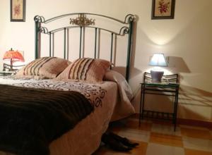 1 dormitorio con 1 cama y 2 mesas con lámparas en Casa Mistral - Casa Rural Los Cuatro Vientos, en Moratalla