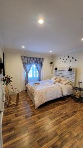 a bedroom with a large bed and a wooden floor at Adorable modern guesthouse with full kitchen in Encino