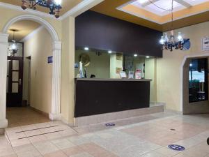 un vestíbulo con un mostrador negro en un edificio en Hotel Plaza CA, en Mérida
