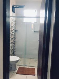 a bathroom with a toilet and a glass shower at Apartamento 403 Bloco I - Condomínio dos lagos II in Capitólio
