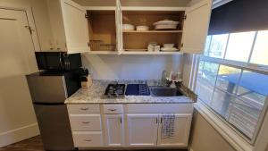 a small kitchen with a sink and a refrigerator at Adorable modern guesthouse with full kitchen in Encino
