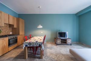 a kitchen with a table with chairs and a television at B&B Portorosso in Monopoli