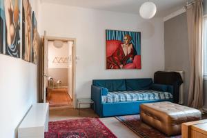 a living room with a blue couch and a painting at living down town in Bassano del Grappa
