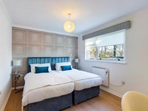 a bedroom with a large bed and a window at Scotchacre Kingsbarns - Walk to Beach & Golf Club in Kingsbarns