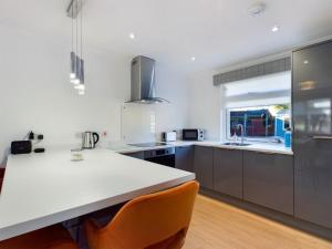 a kitchen with a white counter top and a large window at Scotchacre Kingsbarns - Walk to Beach & Golf Club in Kingsbarns