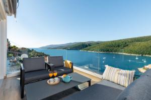 einen Balkon mit Blick auf das Wasser in der Unterkunft D&A Superior Apartman in Rabac