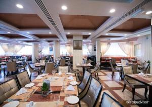 a restaurant with tables, chairs, and tables in it at Garden Hotel Muscat in Muscat