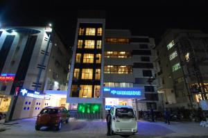 Hotel Ambassador في إندوري: سيارة بيضاء متوقفة أمام مبنى في الليل