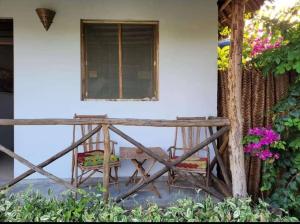 a porch with a bench and a window and flowers at Sweet Home in Kiwengwa