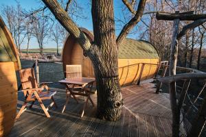 a wooden deck with a tree and a table and chair at Viking houses Strnadovský Mlýn in Jesenice