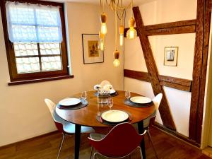 jadalnia z drewnianym stołem i krzesłami w obiekcie Au pied des remparts à Eguisheim w mieście Eguisheim