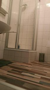 ein Badezimmer mit einem Spiegel und Holzböden in der Unterkunft Gäste und Ferienwohnung Gläser Zwickau in Zwickau