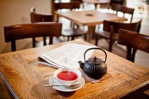 a cup of tea and a tea kettle on a wooden table at B&B Dvor Tacen in Ljubljana
