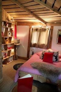 a bedroom with a bed with red pillows at Le Nid Dans Les Bruyères in Fère-en-Tardenois