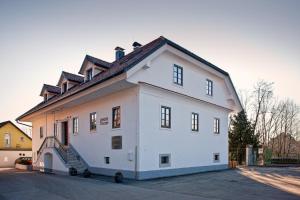 a large white building with a roof at B&B Dvor Tacen in Ljubljana