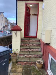 una casa con una puerta roja y escaleras que conducen a ella en Abingdon Owner Apartment 19, en Ryde