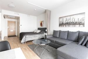 - un salon avec un canapé et une table dans l'établissement Brand-new City Home 33m2, à Tampere
