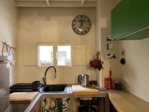 a kitchen with a sink and a clock on the wall at Casa VicoloLungo Nardó in Nardò
