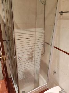 y baño con ducha y puerta de cristal. en Aveiro Theater Rooms, en Aveiro