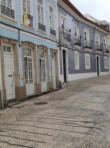 a row of buildings on a cobblestone street at Aveiro Theater Rooms in Aveiro