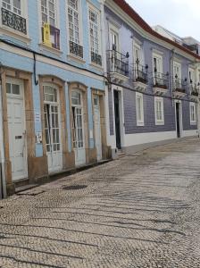 a row of buildings on a cobblestone street at Aveiro Theater Rooms in Aveiro +32 photos