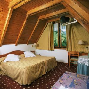 a hotel room with two beds and a window at Hotel Edelweiss in Arties