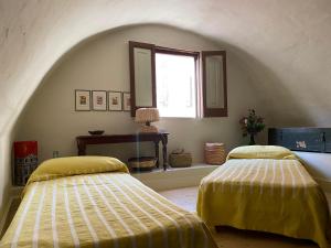 Dos camas en una habitación con ventana. en Casa VicoloLungo Nardó, en Nardò